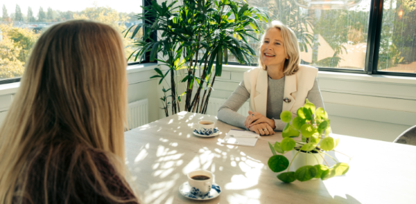 twee mensen in gesprek met een kopje koffie
