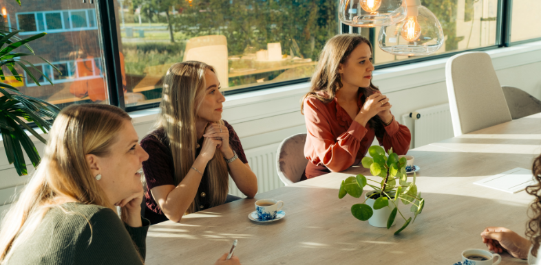Teamoverleg op kantoor over werkdruk en preventie van verzuim