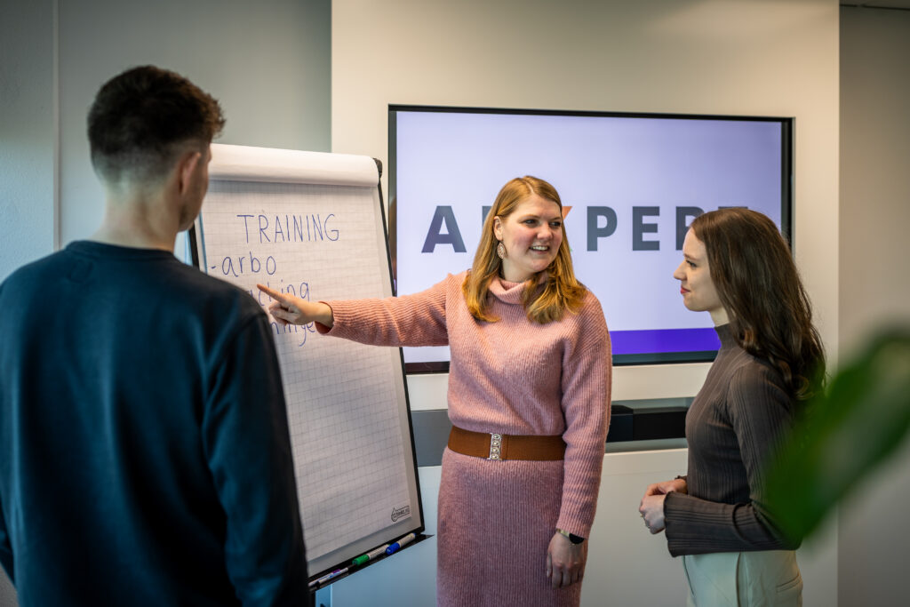 Trainer legt iets uit aan deelnemers tijdens een training gespreksvaardigheden bij ADXpert